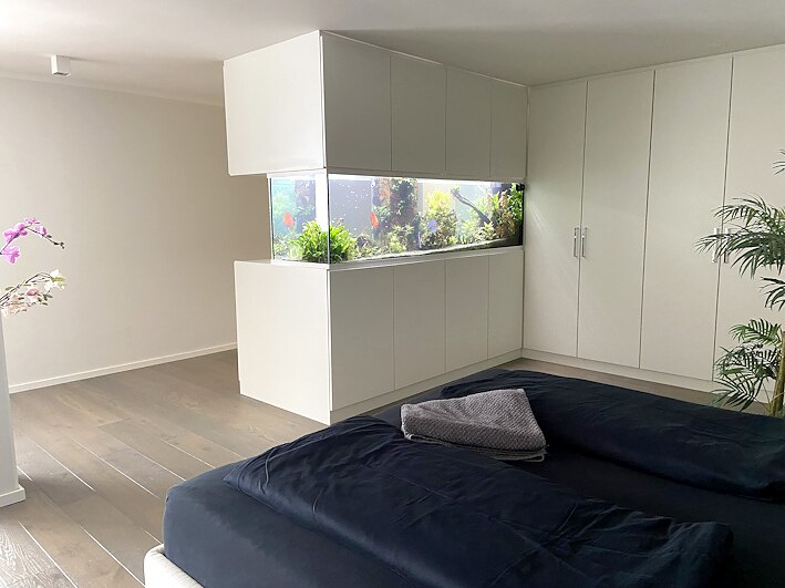 Aquarium in weißem Möbelverbau in einem Schlafraum